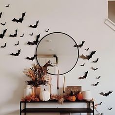 a mirror sitting on top of a table next to a bunch of bats flying over it