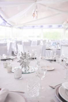 the table is set for an event with white linens and napkins on it