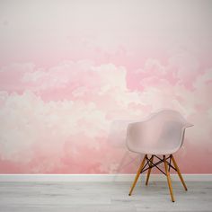 a white chair sitting in front of a wall with clouds painted on it's side