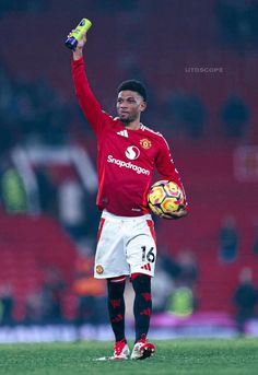 a man holding a soccer ball on top of a field