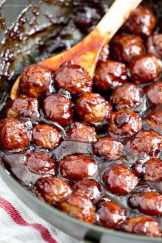 a pan filled with meatballs and sauce on top of a red checkered table cloth