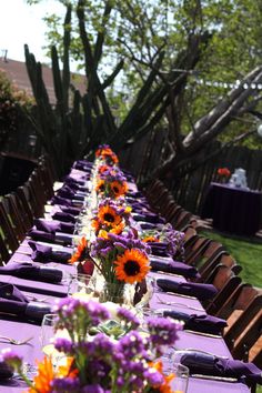 a long table covered in purple and orange flowers