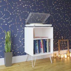 there is a record player on top of a white cabinet