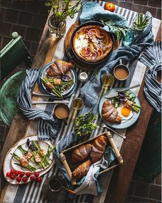 a table topped with plates and bowls filled with food next to other dishes on top of a wooden table