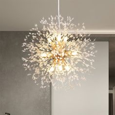 a modern chandelier hanging from the ceiling in a room with white walls and flooring