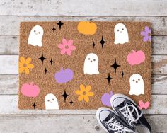 a pair of sneakers sitting on top of a door mat with ghost and stars pattern