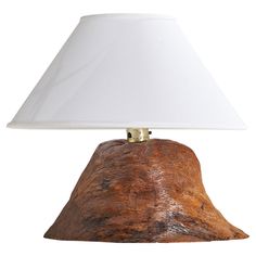 a lamp that is sitting on top of a wooden base with a white shade over it