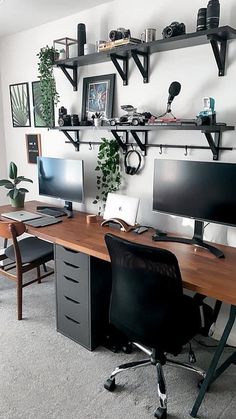 a desk with two computer monitors and a keyboard on top of it in an office