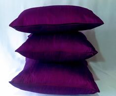 three purple pillows stacked on top of each other