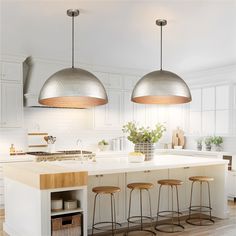 two pendant lights hanging over an island in a kitchen with stools and counter tops