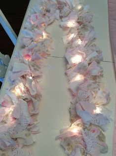 a white table topped with lots of pink and white fabric covered in lightening strips