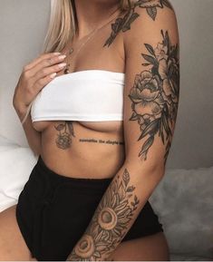 a woman with tattoos on her arm and chest