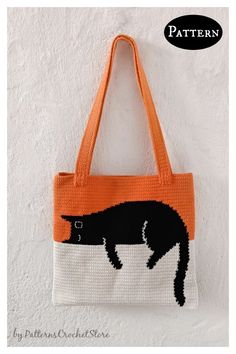 an orange and white bag with a black cat on the front hanging from it's side