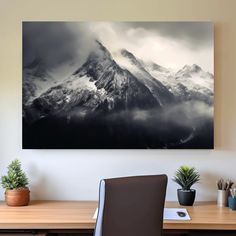 a desk with a chair and a painting on the wall above it that has a mountain in the background