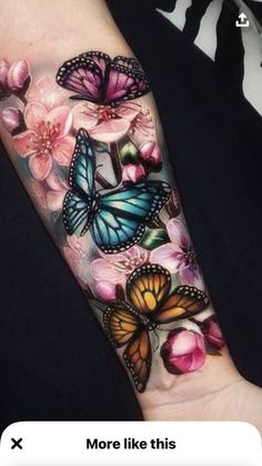 a woman's arm with butterflies and pink flowers on the left side of her arm