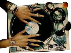 two hands on top of a record player with many different rings and bracelets around it