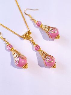 Pink pearl Gold Victorian jewelry set filigree gold set necklace and earrings Boho pink pearl jewelry set Antique style set Gift set Beautiful Set of gold tone filigree ornaments and rose pink acrylic plastic pearls beads and pink little plastic beads pendant necklace and  earrings . Antique style filigree gold tone set necklace and earrings . Gold tone plastic pearls beads Victorian style necklace and earrings . Boho necklace . Boho jewelry set . Boho earrings . Bohemian necklace and earrings . Feminine Pink Jewelry With Earrings, Yellow Gold Filigree Jewelry Sets For Gift, Yellow Gold Filigree Jewelry Sets As Gift, Feminine Pink Jewelry With Pearl Drop, Feminine Pink Pearl Drop Jewelry, Pink Dangle Jewelry Sets For Gifts, Formal Pink Necklaces With Matching Earrings, Elegant Pink Necklace With Intricate Design, Elegant Pink Dangle Necklaces