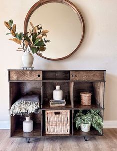 a wooden shelf with baskets and vases on it next to a round mirror in a room