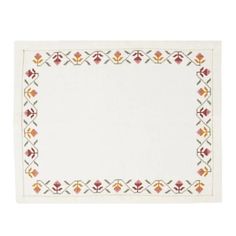 a white place mat with an embroidered border on the front and side, in various colors