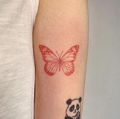 a woman with a tattoo on her arm has a red butterfly and a panda bear