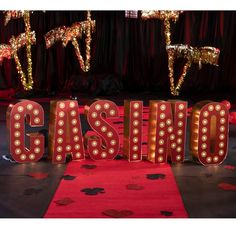 a casino sign that is lit up with lights and confetti on the floor