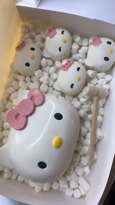 there are hello kitty cakes in the box with rocks and pebbles on the bottom, along with chopsticks