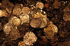 a pile of gold coins sitting next to each other