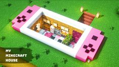 a pink and white toy house on top of green grass