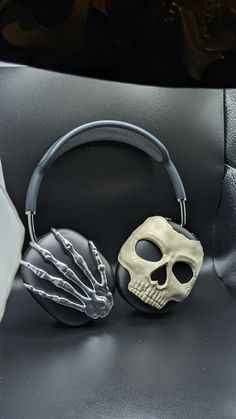 a skull headphone with two hands attached to it's ear cord, sitting on top of a car seat