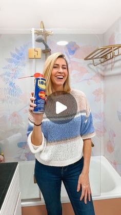 a woman holding up a can of spray paint