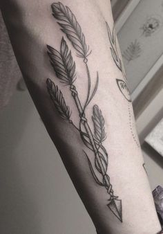 a woman's leg with a tattoo on it and an arrow in the middle