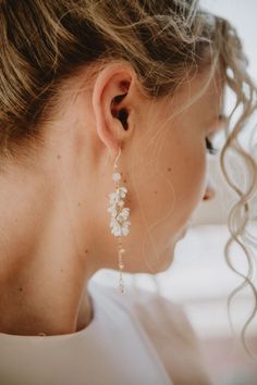 a close up of a person wearing some kind of earring with flowers on it