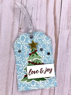 a tag with a christmas tree on it and the words love & joy printed on it