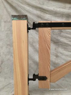 a wooden frame with two metal brackets attached to the top, and one piece of wood on