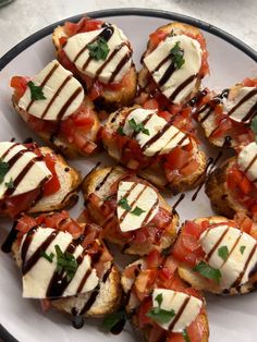 a white plate topped with mini sandwiches covered in cheese and toppings