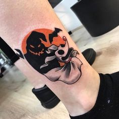 a person with a halloween themed tattoo on their leg