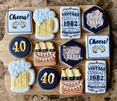 decorated cookies are arranged on a cutting board with beer mugs and other items in the background