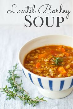 lentil barley soup with carrots and herbs in a blue and white striped bowl