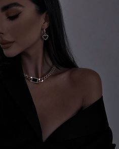 a woman with long black hair wearing a choker necklace and matching earring set