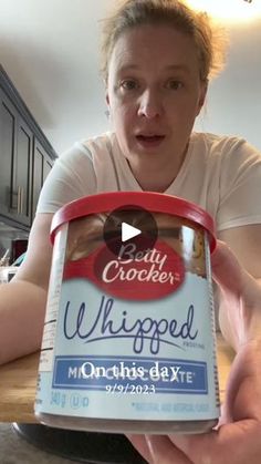 a woman holding up a can of unfilled ice cream in her kitchen with the caption lady crocker whigged