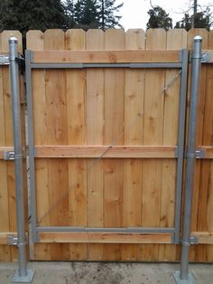 a wooden fence with two metal poles attached to the top and bottom bars on each side