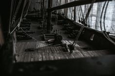 an old wooden boat with ropes on the deck