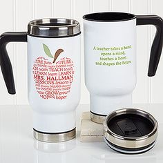 two white coffee mugs sitting on top of a counter next to a cup holder