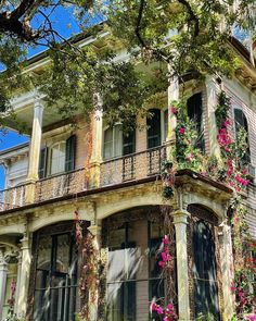 an old house with flowers growing on the balconies