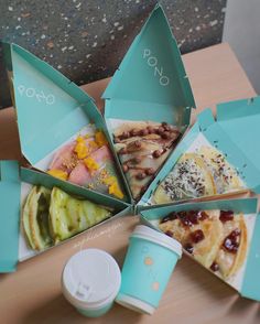 several different types of food in boxes on a table next to a cup with a lid