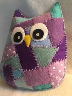 an owl stuffed animal sitting on top of a bed