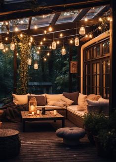 an outdoor living area with lights strung from the ceiling and couches on the deck