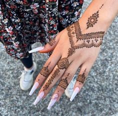 a woman's hand with henna tattoos on it