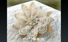 a close up of a flower on a lace tablecloth with grass in the background