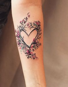 a woman's arm with a heart shaped tattoo on the left side of her arm